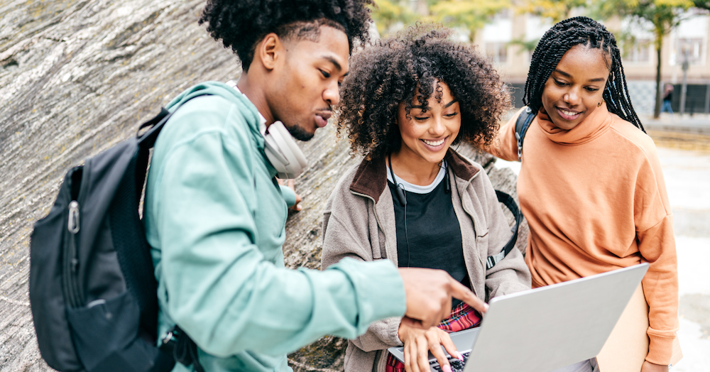 Three college students looking at laptop 